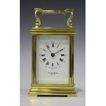 A 20th century lacquered brass carriage timepiece, the white enamel dial with black Roman hours