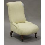 A late Victorian nursing chair, upholstered in cream fabric, raised on turned walnut legs