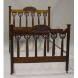 An Art Nouveau walnut double bed frame, carved and pierced with tendril and leaf panels, height