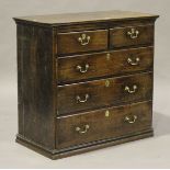 A George III provincial oak chest of two short and three long drawers with applied brass handles,