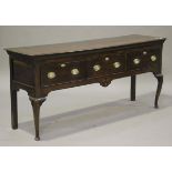 A George III oak dresser base, the moulded top above three frieze drawers, raised on cabriole legs