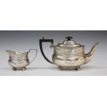 An Edwardian silver teapot and milk jug, each of cushion form with engraved foliate band, London