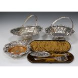 A collection of plated items, including a cake basket with swing handle, raised on a circular