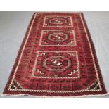 An Afghan kelleh, early/mid-20th century, the shaded plum field with three lozenge medallions,
