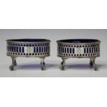 A pair of George III silver oval salts, each with pierced sides and gadrooned rim, fitted with a