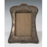 An Art Nouveau silver mounted photograph frame, embossed with stylized scrolls, with oak back and