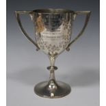 A late Victorian silver two-handled trophy cup, the ovoid bowl engraved with leaves framing