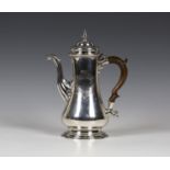 A George II silver coffee pot of tapering low bellied form with domed hinged lid, flanked by a