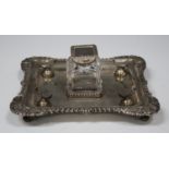 A late Victorian silver inkstand of square form with gadrooned and scallop shell cornered rim,