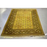 An Afghan rug, mid-20th century, the golden yellow field with an overall hooked gul lattice,