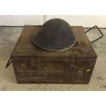 A military tin helmet and ammunition box.