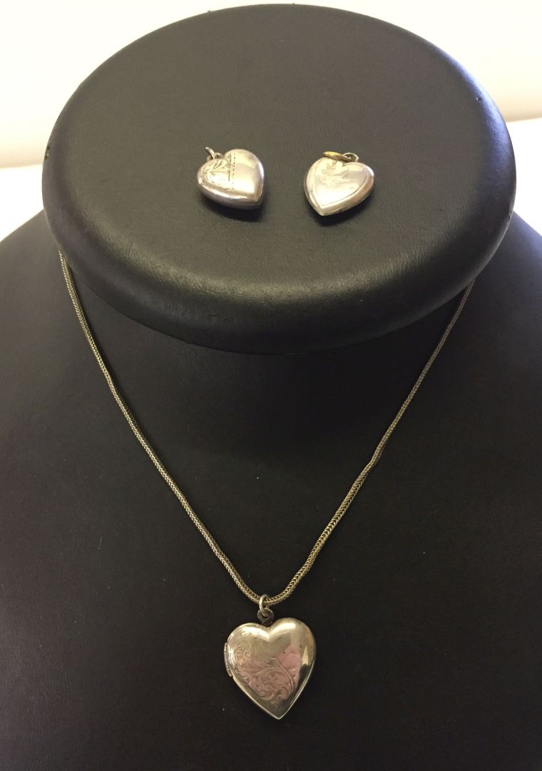 A hinged and engraved silver locket on a chain together with 2 engraved heart shaped silver