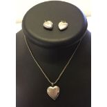 A hinged and engraved silver locket on a chain together with 2 engraved heart shaped silver