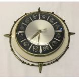 A c1960-70s metalware electric wall clock with signs of the zodiac to face. Not tested.