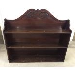 A mahogany bookshelf with shaped decoration to top. Approx 95 x 85cm.