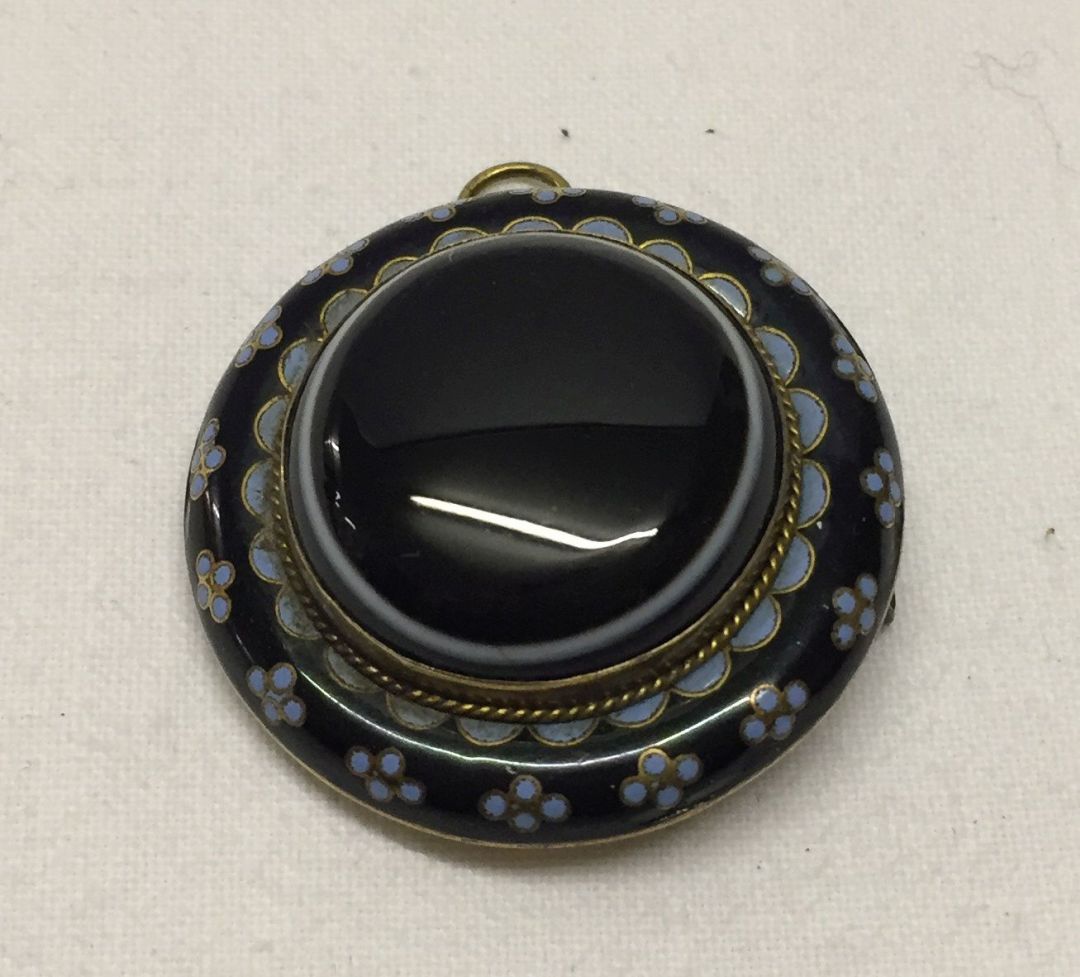 A Victorian mourning pendant/brooch. Navy and pale blue enamel to outside, middle a banded agate.