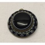 A Victorian mourning pendant/brooch. Navy and pale blue enamel to outside, middle a banded agate.