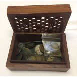 Wooden box containing various world coins.