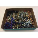 A box containing a large quantity of vintage and modern costume jewellery, mostly beaded necklaces.