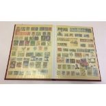 A maroon stamp album containing stamps from the Commonwealth.