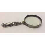 A silver handled magnifying glass. Hallmarked rubbed lens 8.5cm diameter. Chips to lens.