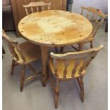 A modern circular pine kitchen table and 4 pine chairs.