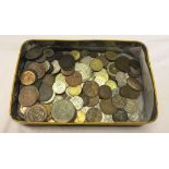 A tin of various world coins.