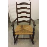 A dark oak rocking chair with rush seat.