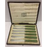 A cased set of 6 Harrods green handled butter knives (1 a/f).