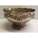 A silver on copper vintage punch bowl with floral garland decoration.