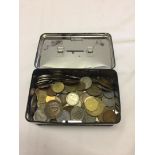 A black money tin containing world coins.