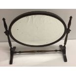 A Victorian oval shaped mahogany swing mirror.