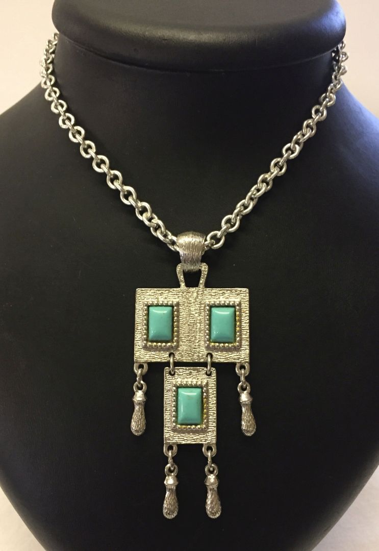 A vintage Sarah Coventry silvertone pendant on a 30" chain with decorative turquoise blue panels.