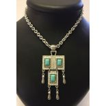 A vintage Sarah Coventry silvertone pendant on a 30" chain with decorative turquoise blue panels.