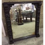 A large antique mirror with carved wood decoration 98 x 89cm.