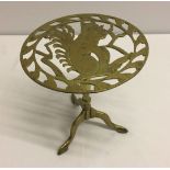 A brass trivet on tripod stand depicting a squirrel.