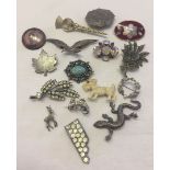 A collection of brooches to include marcasite, Mexican silver and early plastic.