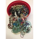 A round tub with large amount of modern and vintage costume jewellery.