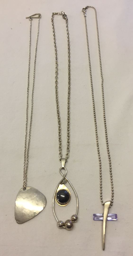 3 contemporary style silver pendants on silver chains including a cross design set with a crystal (
