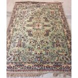 A large wool mix rug in green, cream and blue colours. Approx 200 x 285cm.