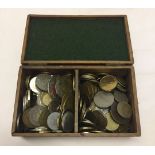 A wooden box containing world coins.