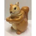 A large ceramic cookie jar in the shape of a squirrel.