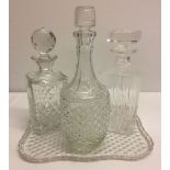 3 glass decanters on a glass tray.