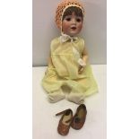 A vintage German bisque head doll with tremble tongue. 22 inches tall. Head marked 52 Made in