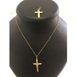 A 9ct gold crucifix measuring 4cm long (to the top of the bale) together with a 9ct gold cross and a