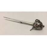 Antique basket handled sword brooch measuring 9cm long. Hilt is in white metal figure work over a