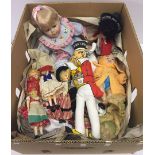 A box containing 9 dolls comprising 6 vintage costume of the world dolls, a vintage celluloid doll ,