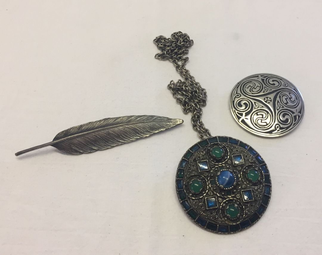 3 items of costume jewellery comprising St. Justin brooch, a feather brooch and a Miracle