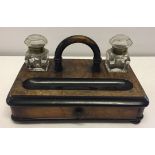 A ebonised walnut standish complete with glass inkwells and a collection of ink pens.