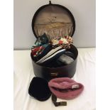 A vintage large vanity case containing vintage hats and feather accessories.